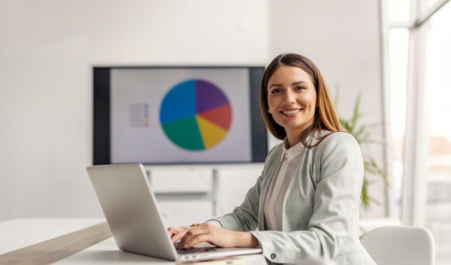 Weiterbildung Online Marketing Manager IHK: Teilnehmerin arbeitet am Laptop mit digitalen Marketingkennzahlen und Diagrammen.